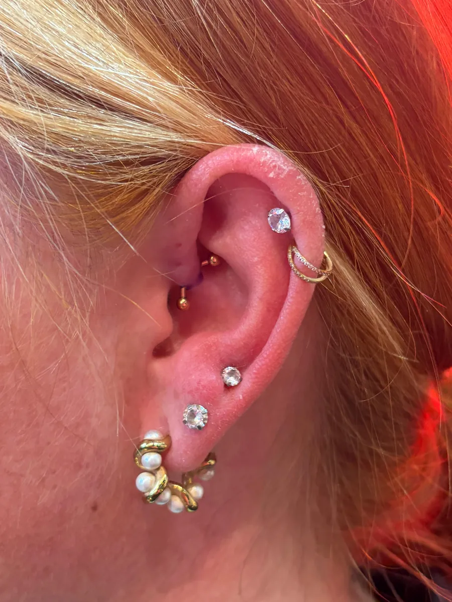 Helix, conch ve lob piercinglerinin birlikte planlandığı ear curation örneği